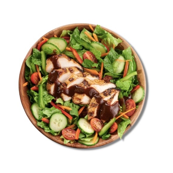 Jerk Chicken Salad in a wooden bowl with mixed greens, cucumber, tomato, and carrot